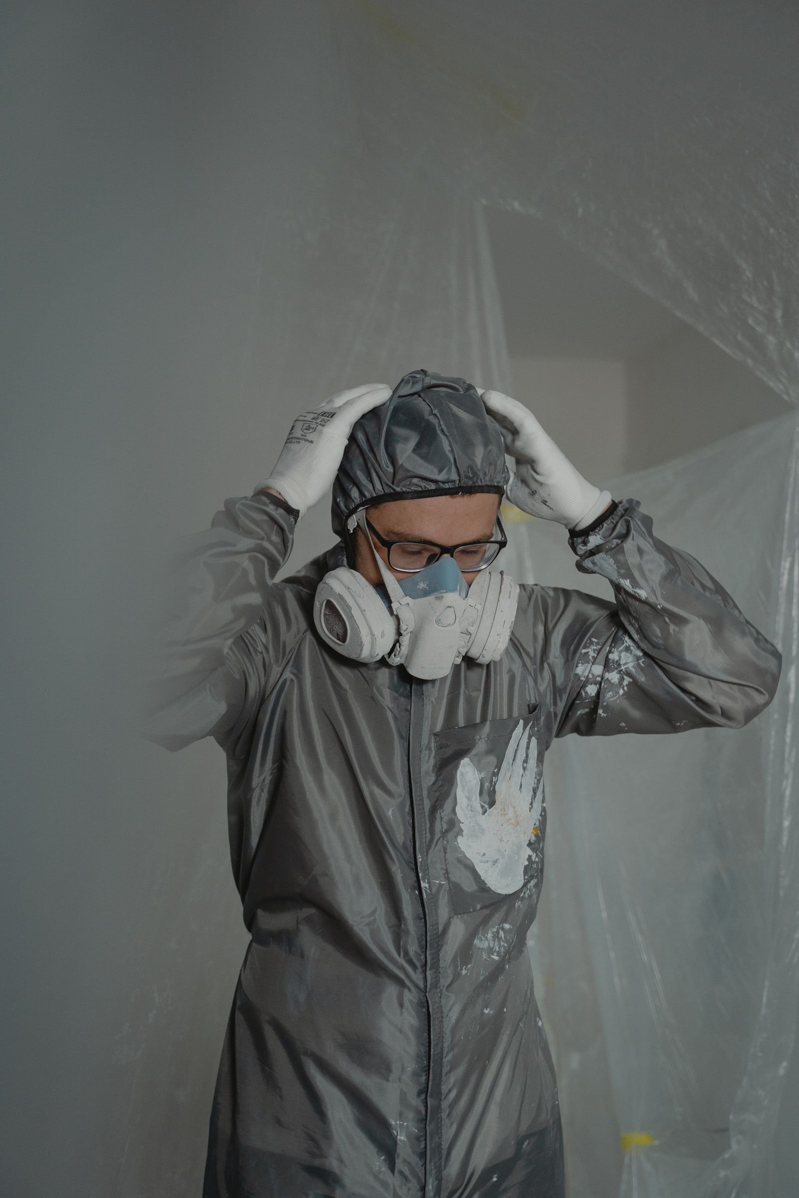 Travailleur en combinaison de protection et masque respiratoire avant une décontamination de moisissure selon la norme IICRC S520, à Montréal