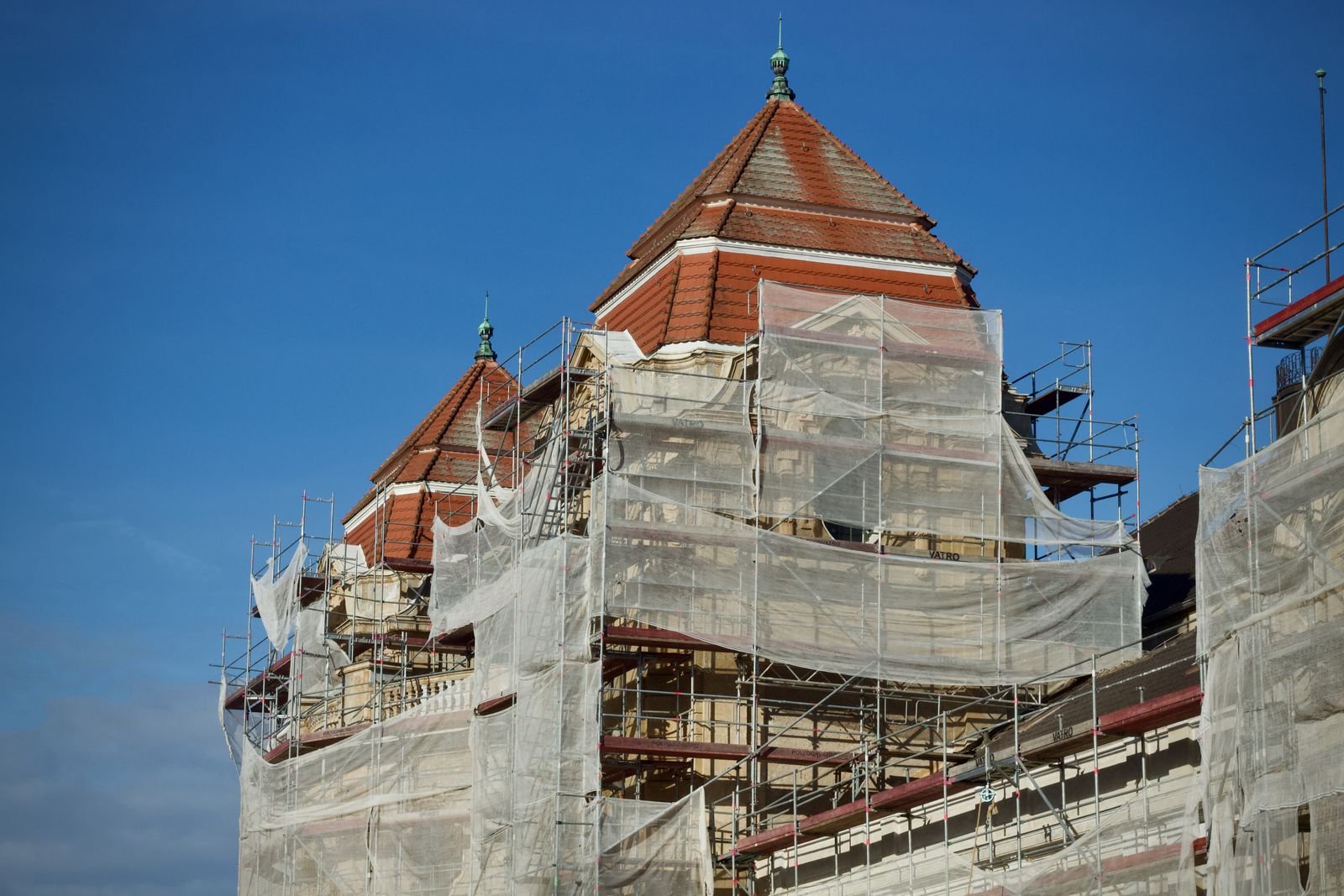 Bâtiment patrimonial à tourelle couvert d’échafaudages pendant la réfection de sa toiture, un type de chantier que l’on mène à Montréal et dans ses environs