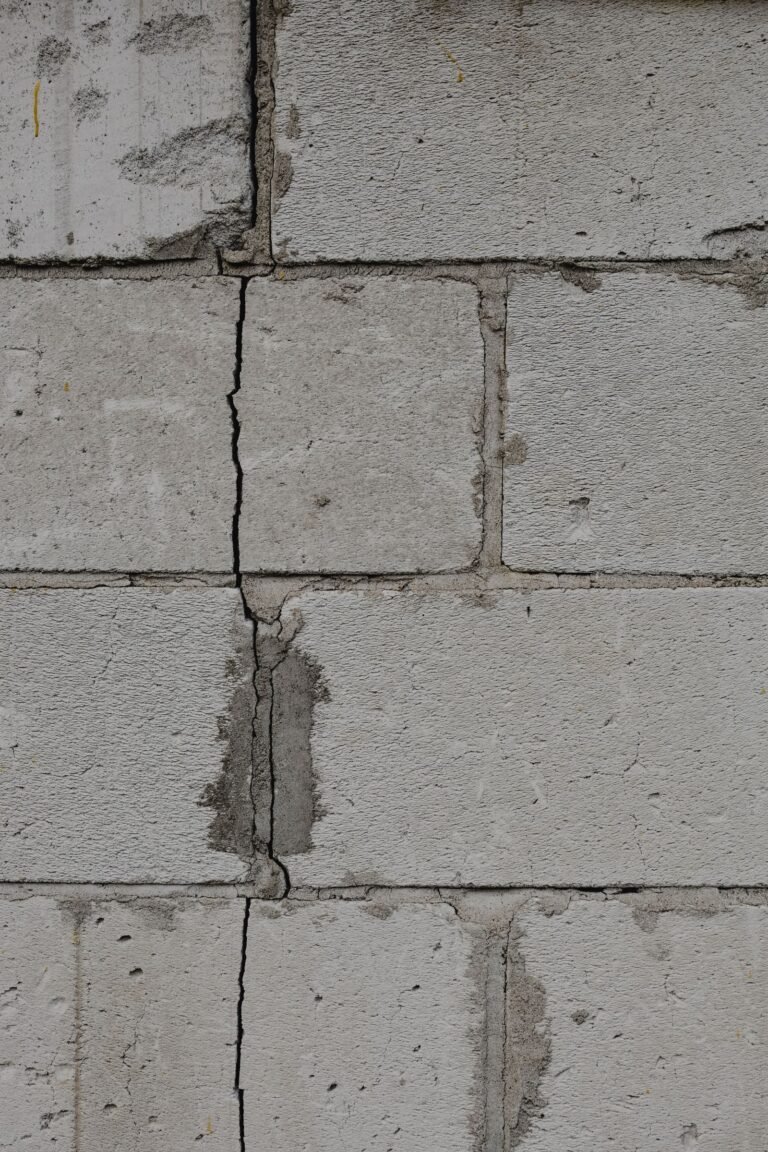 Fissure verticale dans un mur de fondation en blocs de béton, colmatée au mortier, dans un sous-sol de la région de Montréal