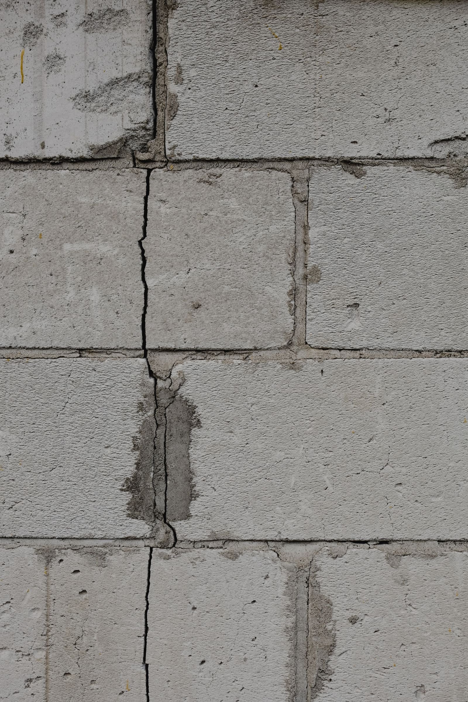 Fissure verticale dans un mur de fondation en blocs de béton, colmatée au mortier, dans un sous-sol de la région de Montréal
