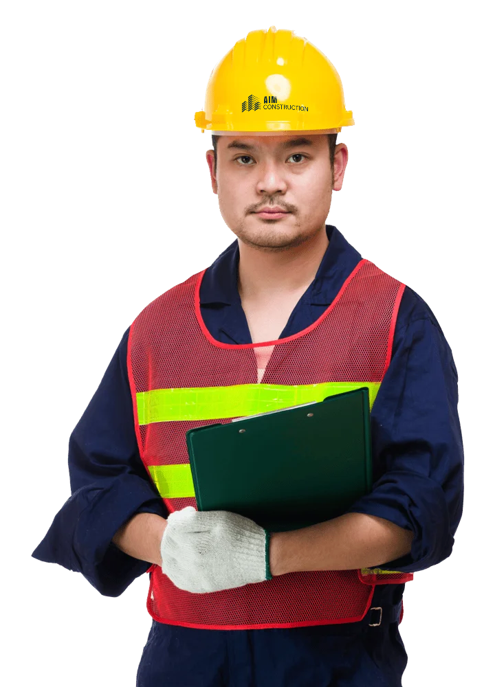 Travailleur de chantier portant un casque aux couleurs de Construction AIM, entrepreneur général à Montréal