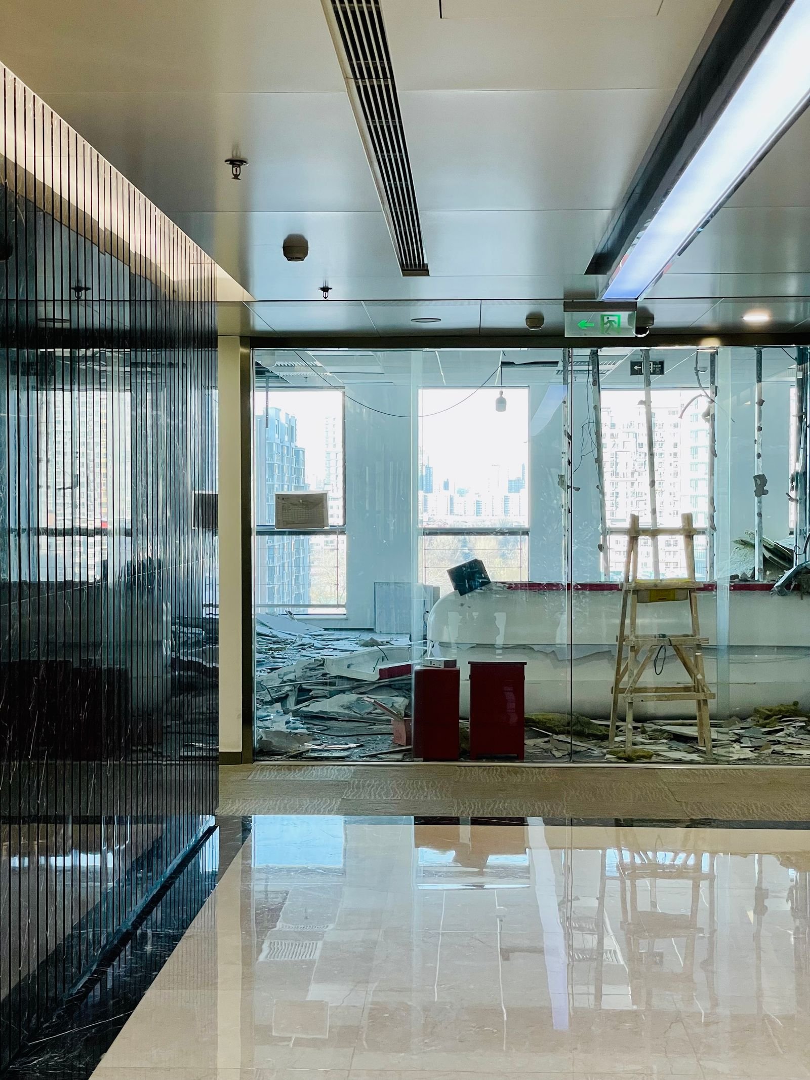 Rénovation de bureaux dans un immeuble occupé : zone de chantier isolée derrière des portes vitrées, entrepreneur général à Montréal